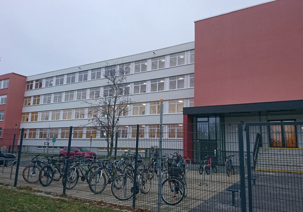 Blick auf das vierstöckige Schulgebäude und den Fahrradstellplatz